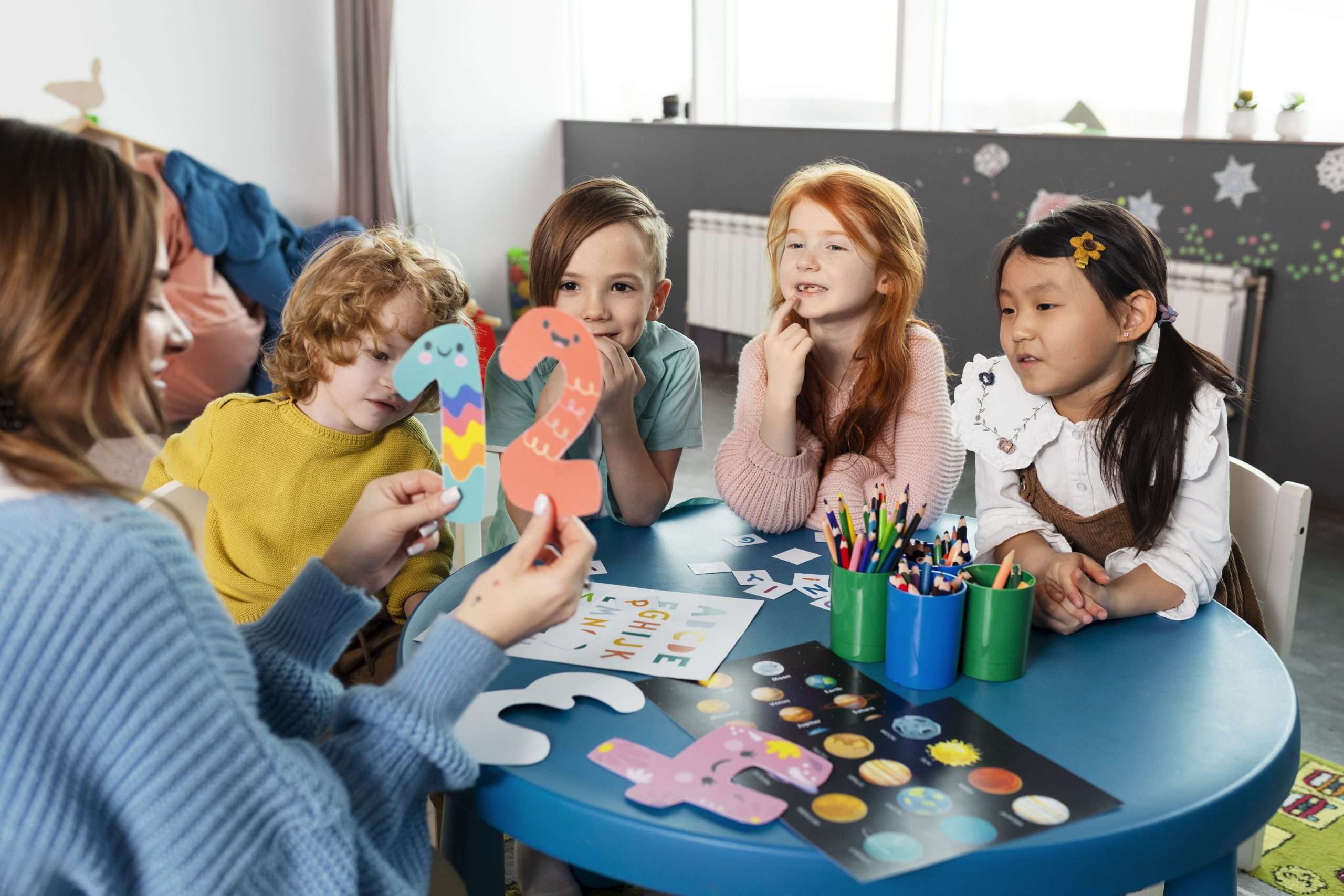 Éducatrice animant un atelier d'éveil avec un groupe d'enfants en micro-crèche