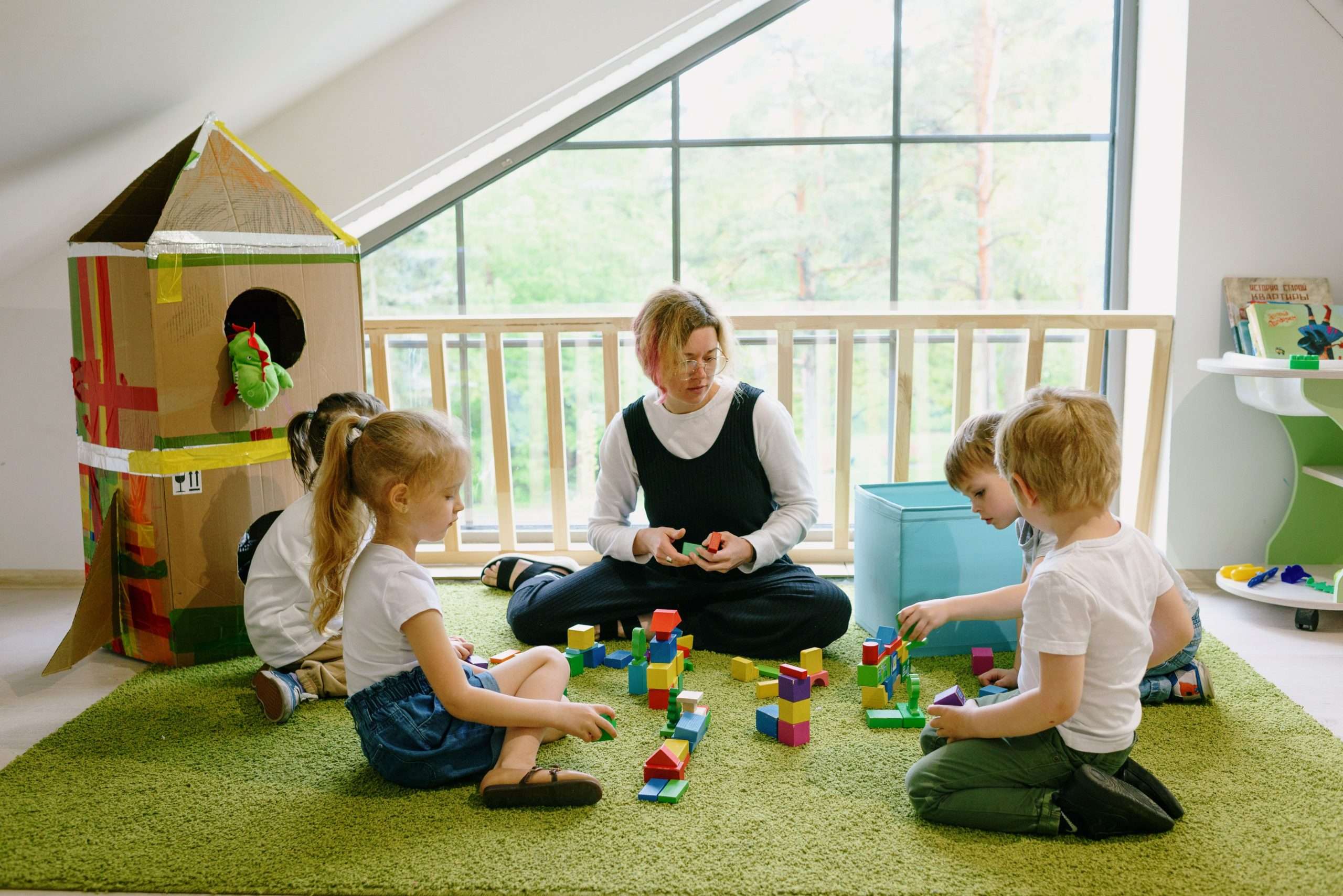 Éducatrice jouant aux cubes avec des enfants dans une micro-crèche
